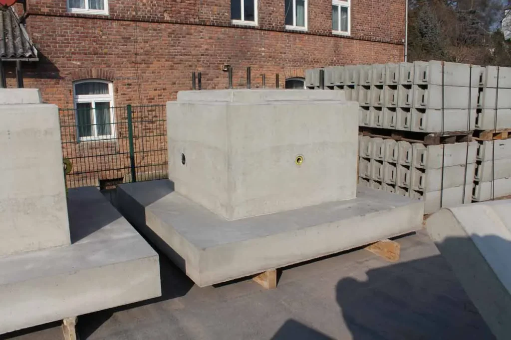 Betonfundament für Umspannwerke auf einer Baustelle, umgeben von weiteren Betonblöcken.