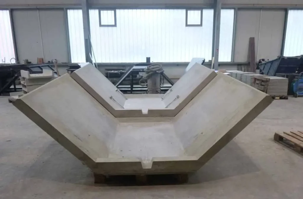 Beton-Kaskade in einer Werkstatt, die eine V-Form aufweist und auf Paletten steht.