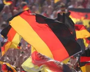 Eine deutsche Flagge weht in einer Menschenmenge während einer Veranstaltung oder Feier.
