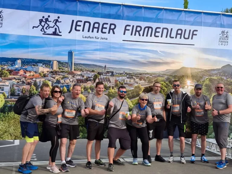 Gruppe von Teilnehmern am Jenaer Firmenlauf, die in sportlicher Kleidung posieren.